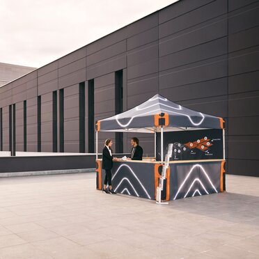 The folding gazebo serves as an information stand on the exhibition grounds. The staff provide information about the fair and exhibitors.